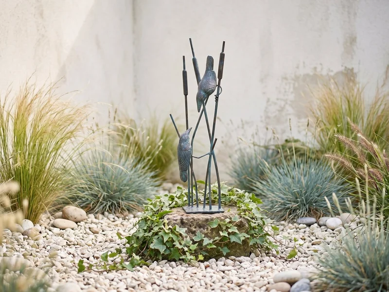 Bronzed songbirds on reeds garden ornament among lavender and roses in a coastal garden border