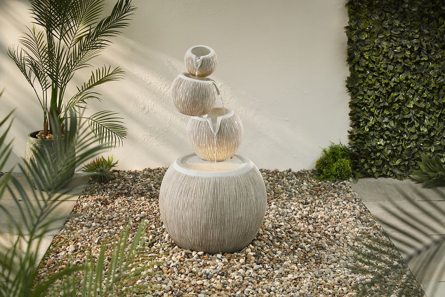Poseidon self contained water feature in a dark north-facing corner of a UK garden